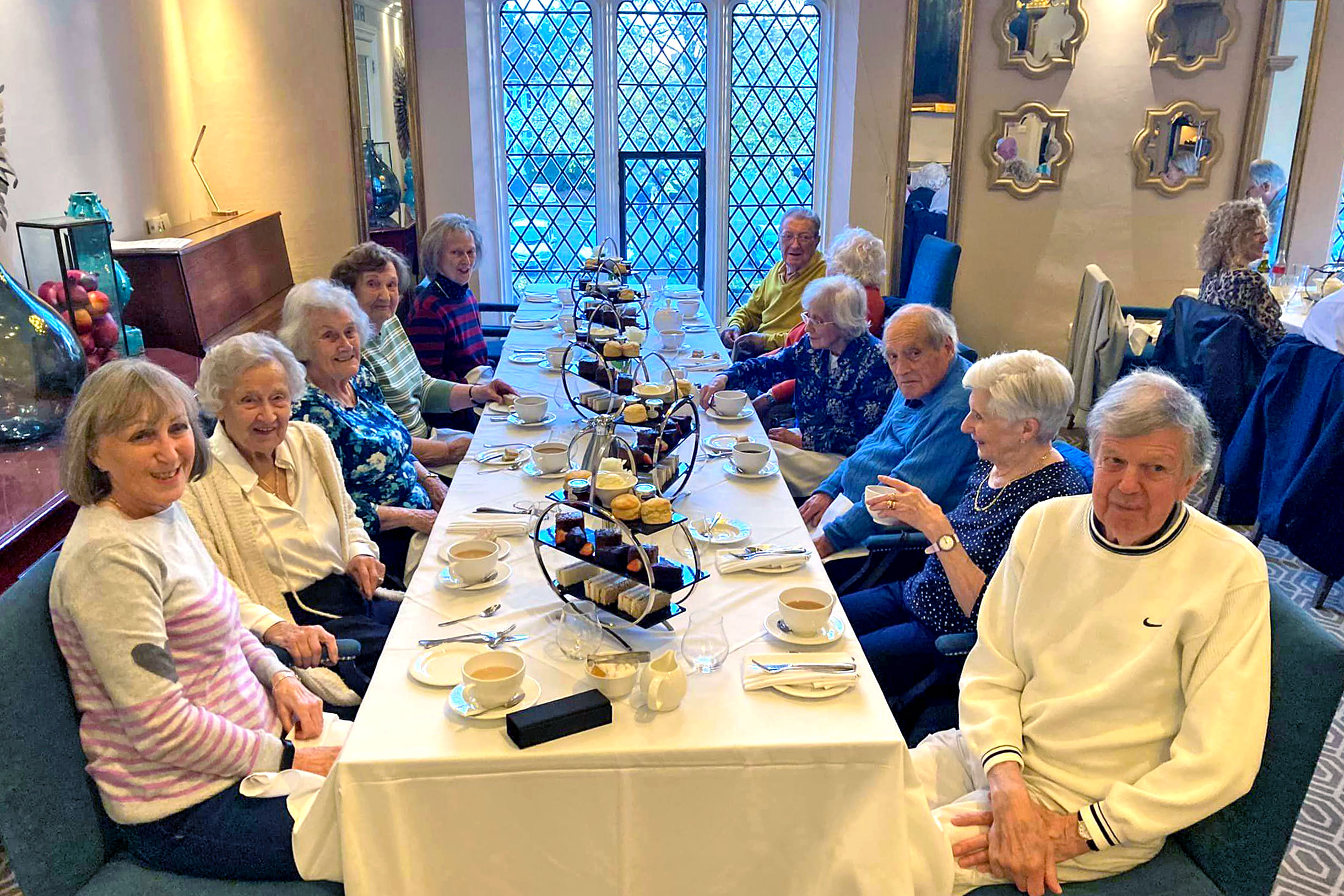 People take afternoon tea at a long table